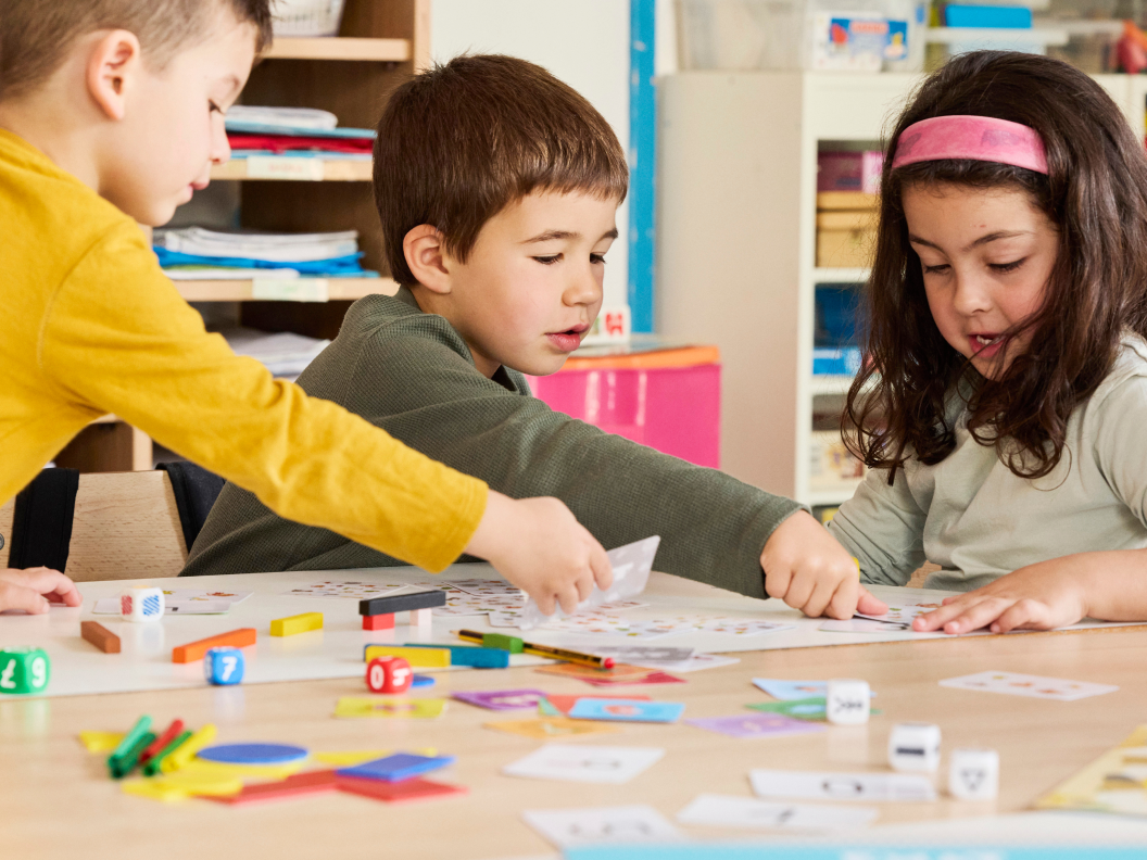 Alumnes de primària treballant junts amb materials educatius a classe